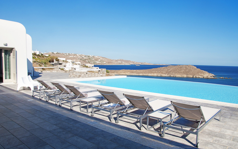 [pool with sunbeds overlooking the sea