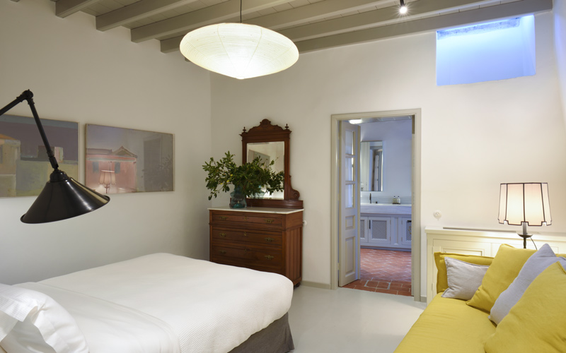 double bedroom with a small sofa