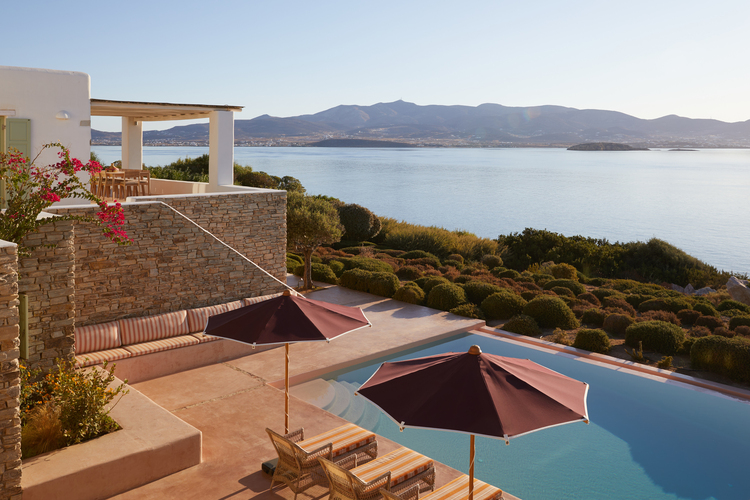 pool area with sunbeds and sea view